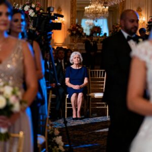 AT MY SON’S LUXURY WEDDING, I WAS SEATED IN ROW 14 – RIGHT BY THE SERVICE AREA. “YOUR POVERTY WILL EMBARRASS US,” HIS BRIDE WHISPERED. THEN, A MAN IN A BLACK SUIT SAT BESIDE ME AND SAID, “LET’S PRETEND WE CAME TOGETHER.” WHEN MY SON LOOKED DOWN AND SAW US, HIS FACE TURNED WHITE.